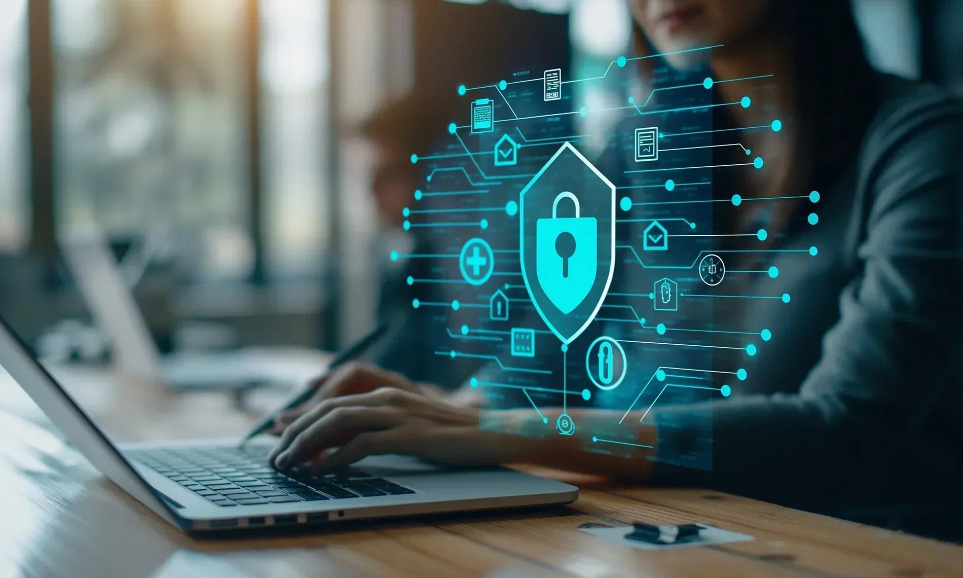 Woman working on laptop with holographic security lock floating next to the laptop. 