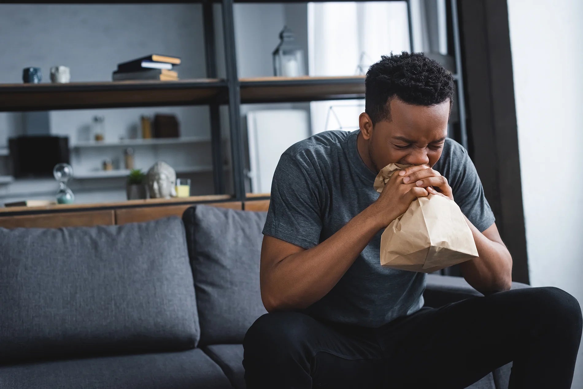 Man sitting on couch hyperventilating