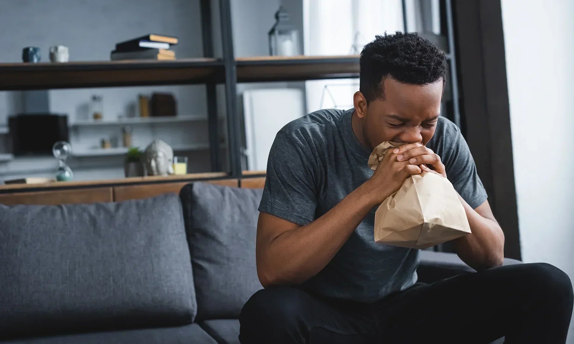 Man sitting on couch hyperventilating