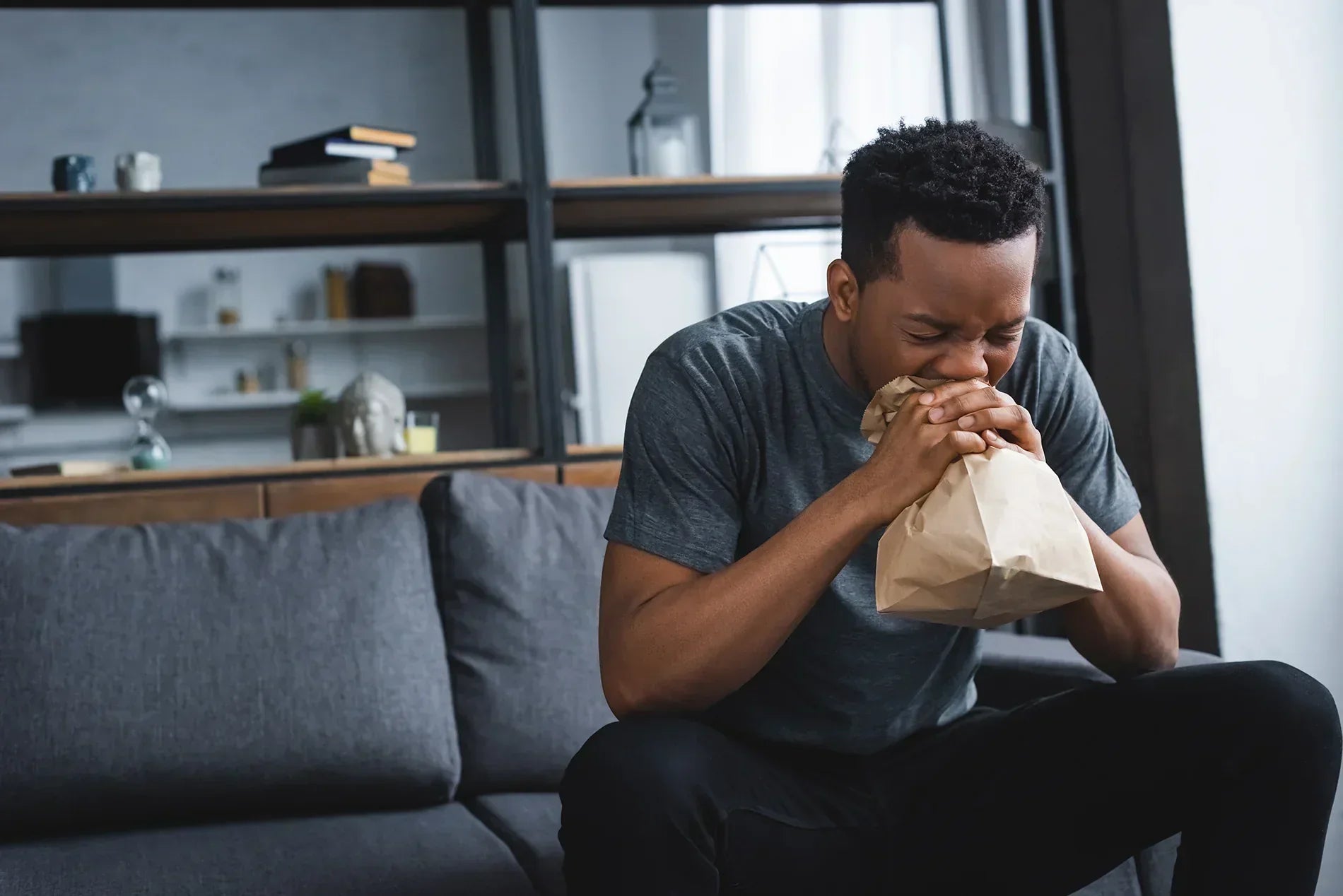 Man sitting on couch hyperventilating
