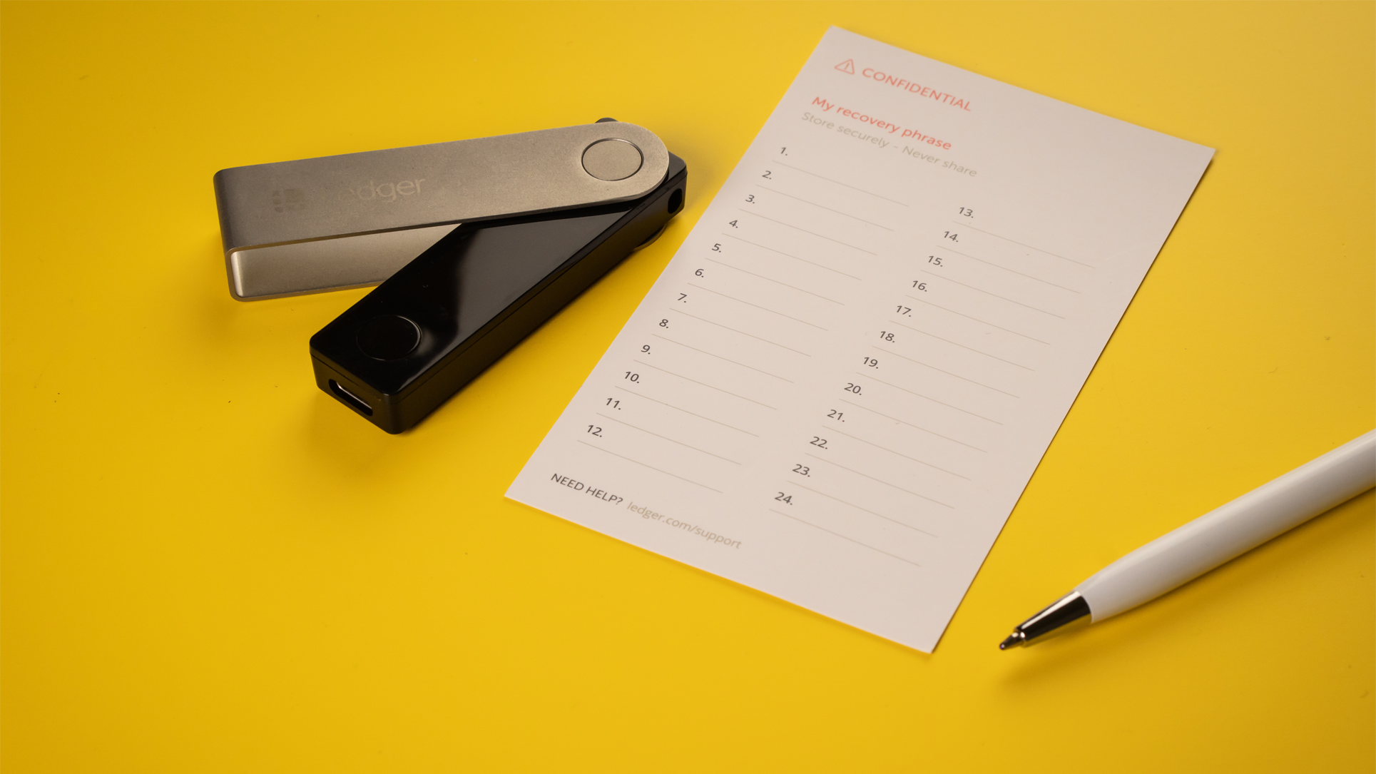 Ledger Nano X and an empty paper seed phrase.