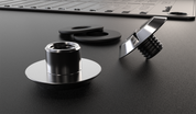 Close-up of a secure fastening system featuring two metal screw components, rubber washers, and a metal crypto backup plate in the background.